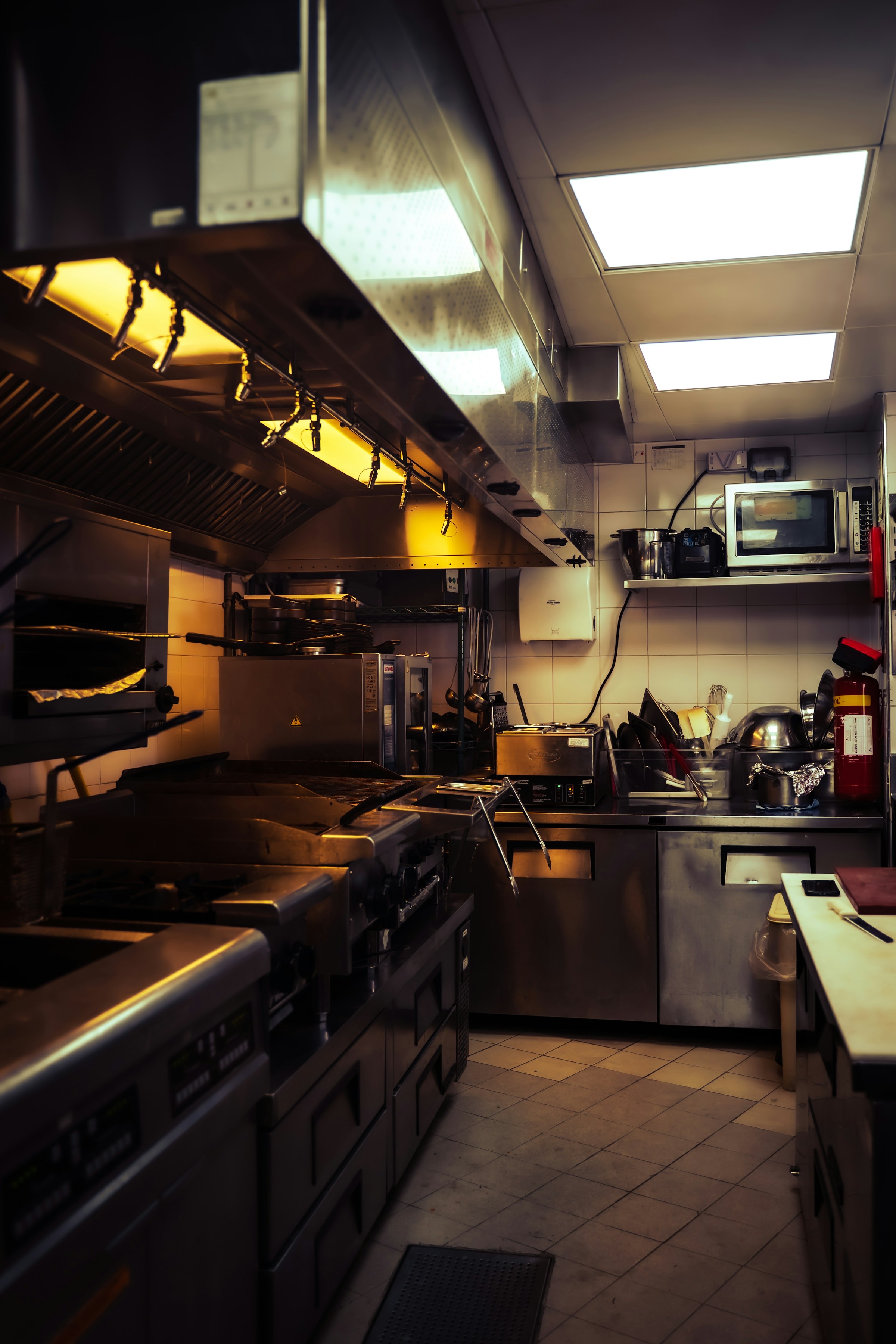 Commercial kitchen with stainless steel cooking equipment and ventilation