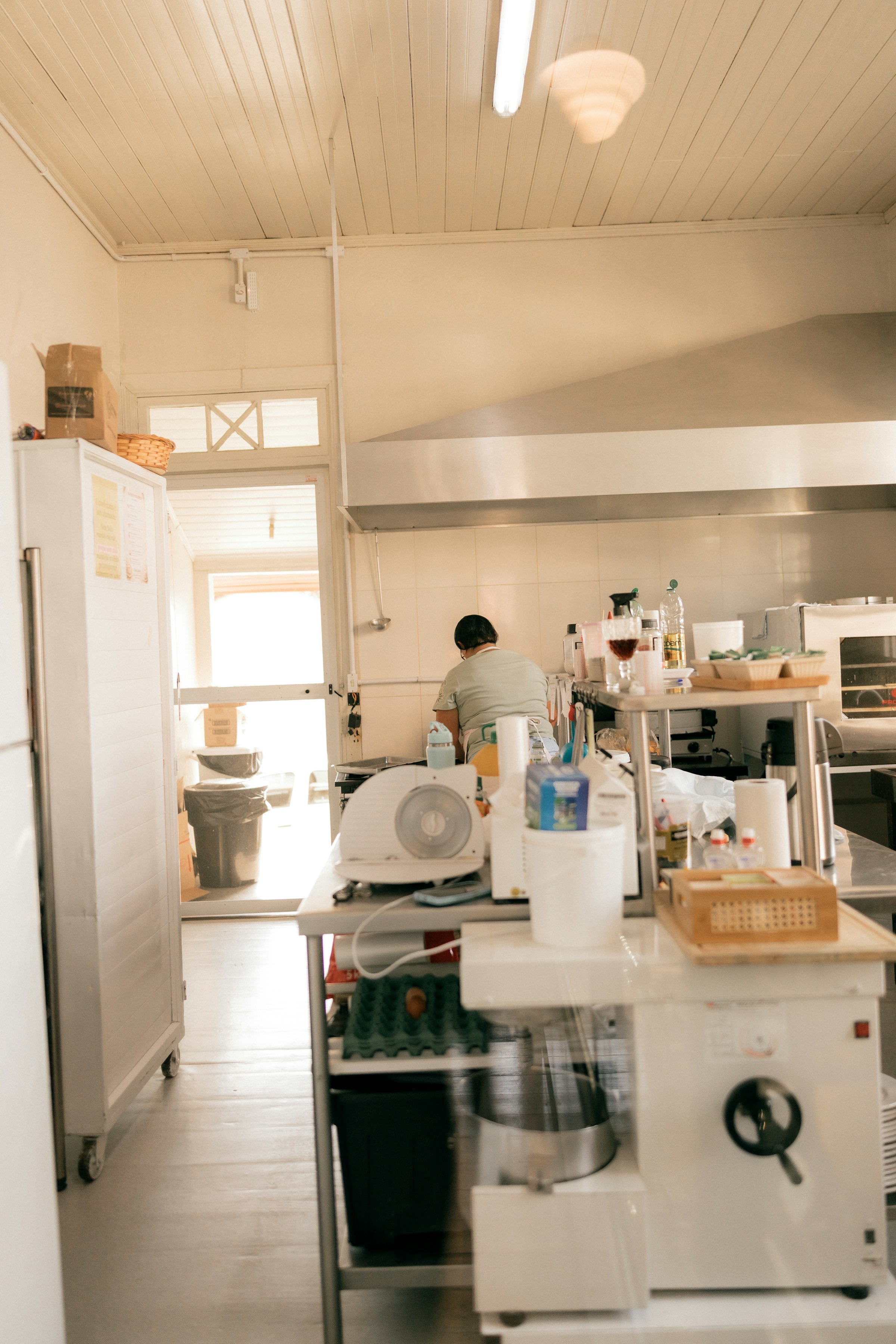 Hospitality foodservice worker preparing food in a bright commercial kitchen