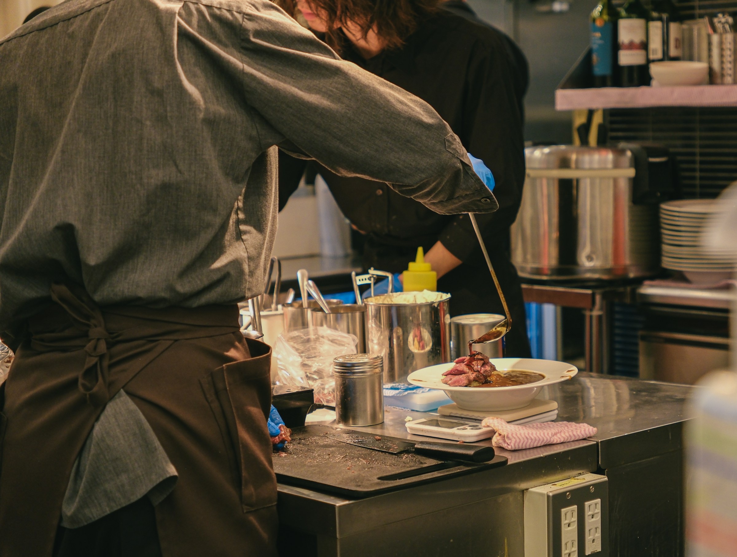 Chefs plating food in a professional restaurant kitchen